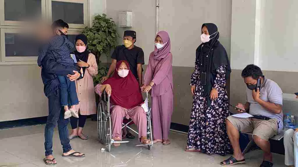 KEHILANGAN : Marwiah (kursi roda), istri Muhammad Yamin, korban kecelakaan maut di turunan Muara Rapak didampingi keluarga di teras ruang mortuary, RSKD Balikpapan, Rabu (23/2).