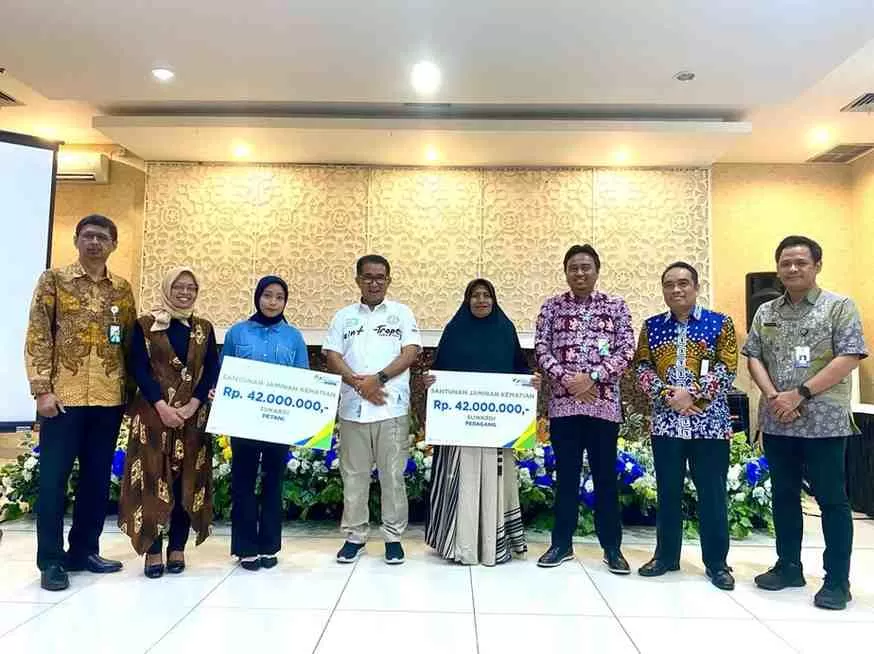 Pj Gubernur Kaltim Akmal Malik didampingi Kepala Kantor BPJS Ketenagkerjaan Cabang Samarinda Agus Dwi Fitriyanto menyerahkan secara simbolis santunan kematian pekerja rentan kepada perwakilan ahli waris, Kamis (11/1) malam. (Foto : Erik Alfian / Prokal.co)