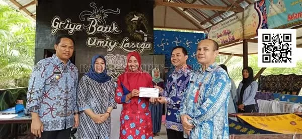 BANTUAN ; Kepala Bank Kalteng Cabang Nanga Bulik Frima Kuayanto didampingi Bupati Hendra Lesmana saat menyerahkan bantuan kepada pimpinan Griya Batik Umiy Lasega yang akan mengikuti event Jakarta Fashion Week 2020.(RIA MEKAR/RADAR PANGKALAN BUN)