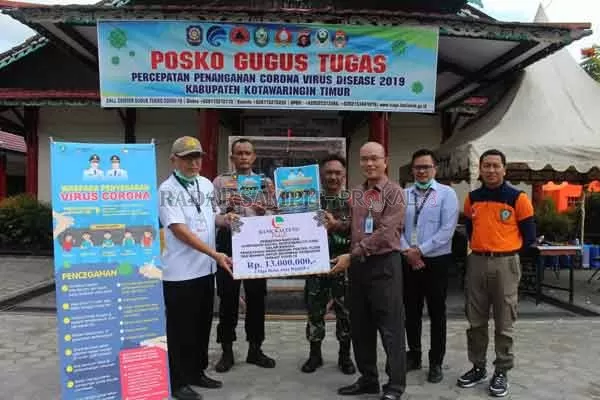 BANTUAN: Kepala Bank Kalteng Cabang Sampit H. Tajudinnor Asra menyerahkan CSR kepada Kepala Dinas Kesehatan Kotim dr. Faisal Novendra Cahyanto di Posko Gugus Tugas Penanganan Corona Virus, Rabu (1/4).