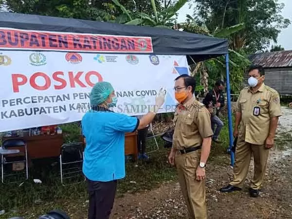 POSKO : Bupati Katingan Sakariyas diperiksa suhu tubuh ketika memantau posko tim gugus tugas penanganan virus Korona (Covid-19) di Desa Hampangen, belum lama ini. (HARI/RADAR SAMPIT)