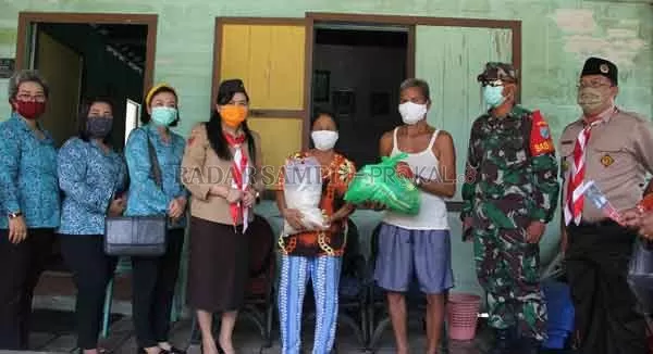 SERAHKAN: Ketua Kwarcab Gerakan Pramuka Kabupaten Gumas Mimie Mariatie Jaya S Monong menyerahkan bantuan sembako dan masker kepada lansia di Desa Petak Bahandang, Kecamatan Kurun, pekan lalu.(ARHAM SAID/RADAR SAMPIT)