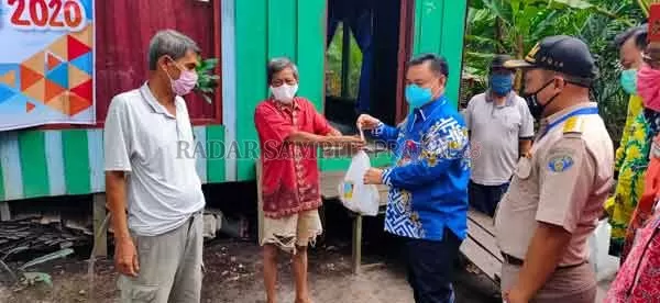 RINGANKAN WARGA: Sekda Kotim Halikinnor saat menyerahkan bantuan  masing-masing 2 Kilogram ikan segar kepada warga Desa Eka Bahurui Kecamatan Mentawa Baru Ketapang, Kamis (14/5).(YUNI/RADAR SAMPIT )