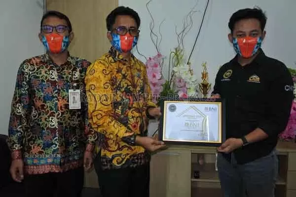 APRESIASI: Ketua DPC Appernas Jaya Kabupaten Kotawaringin Timur Febri Dwitananda memberikan penghargaan kepada Kepala BNI Cabang Sampit Agung FS Ibat, Senin (6/7).(HERU/RADAR SAMPIT)