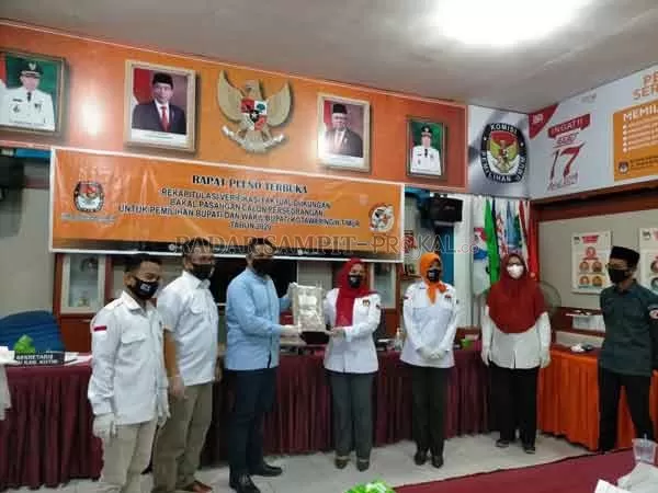 PENYERAHAN: Ketua KPU Kotim Siti Fathonah Purnaningsih menyerahkan berita acara hasil rapat pleno rekapitulasi kepada bacalon wakil bupati Kotim Rusmadi Abdullah di aula Rumah Pintar Pemilu Kantor KPU Kotim, Senin (20/7).(HENY/RADAR SAMPIT)