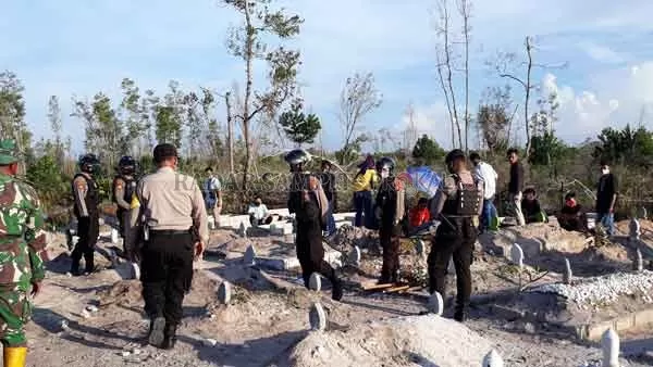 DIJAGA KETAT: Petugas kepolisian saat berjaga di sekitar pemakaman umum Km 12 setelah terjadinya pemukulan oleh keluarga pasien, Selasa (21/7). (DODI/RADAR SAMPIT)