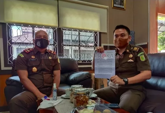 BERHALANGAN HADIR : Kasi Pidsus bersama Kajari Kobar menunjukkan surat keterangan dokter bahwa tersangka Daniel sedang sakit sehingga tak bisa memenuhi panggilan Kejaksaan Negeri Kobar, Kamis (23/7). (SYAMSUDIN/RADAR PANGKALAN BUN)