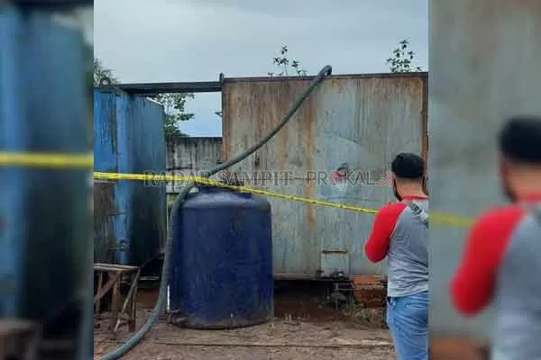 TKP: Seorang petugas Kepolisian memasang garis Polisi, setelah mendapatkan laporan bawah ada yang melakukan penggelapan minyak sawit.*(istimewa)