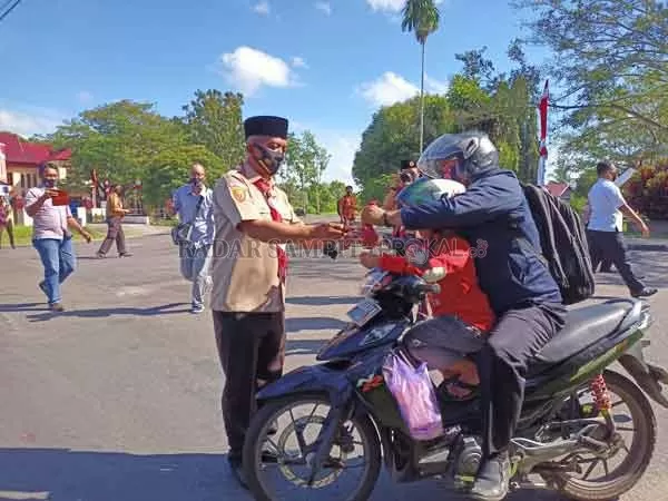 BAKSOS: Ketua Kwarcab Seruyan Seruyan Zuli Eko Prasetyo (kiri) saat memberikan masker gratis kepada salah satu masyarakat yang melintas di Jalan A. Yani bundaran 2 Kuala Pembuang, Rabu (19/8) kemarin.(      (ALDI SETIAWAN/RADAR SAMPIT))