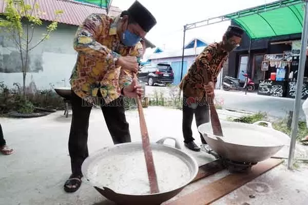 MENGAWAH:  Plt Camat Baamang Rody Kamislam bersama Lurah Baamang Hulu Kasmojoyo ikut mengaduk bubur  asyura atau biasa disebut dengan mengawah. Kegiatan ini dalam rangka menyambut  1 Muharram 1442 hijriah.(USAY NOR RAHMAD/RADAR SAMPIT)