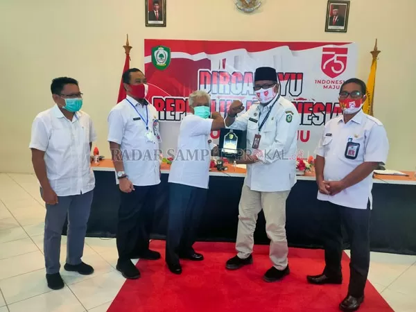 PLAKAT : Juru Bicara (Jubir) Satuan Tugas Penanganan Covid-19 Kotim Multazam menerima, plakat dari Asisten I Bidang Pemerintahan Sekretariat Daerah Kota Palangka Raya, Murni D Djinu usai kegiatan koordinasi dan kaji banding pelaksanaan program pemulihan Ekonomi Kotim, bertempat di Ruang Command Center Dinas Komunikasi dan Informatika Kotim, Rabu (26/8).(HENY/ RADAR SAMPIT)