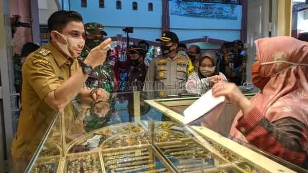 TINJAU: Bupati Kotim Supian Hadi saat berinteraksi dengan sejumlah pedagang saat kegiatan razia masker yang berlangsung di PPM Sampit, Selasa (1/9).(YUNI/RADAR SAMPIT)