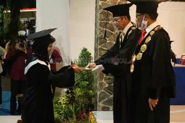 WISUDA: Mayang Sari saat mengikuti wisuda di halaman depan gedung Universitas Palangka Raya, Rabu (2/9).(ISTIMEWA FOR RADAR SAMPIT )
