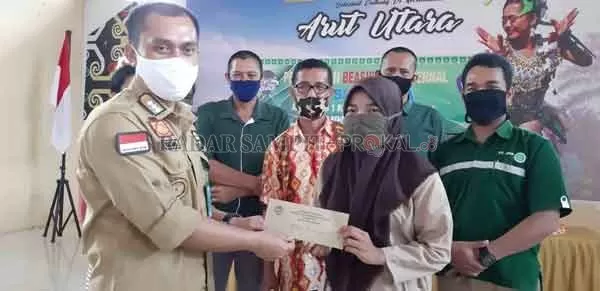 BANTUAN PERUSAHAAN : Camat Arut Utara, Nursyah Ikhsan menyerahkan secara simbolis beasiswa dari PT SINP-PBNA kepada penerima di Kecamatan Arut Utara, Kamis (10/9).(RADAR PANGKALAN BUN)