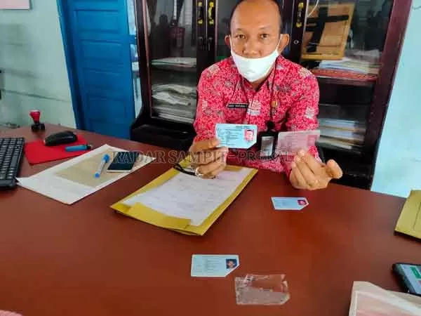BERBEDA: Kepala Disdukcapil Kotim Agus Tripurna Tangkasiang menunjukkan perbedaan kartu identitas asli (kanan) dan palsu (kiri), Kamis (10/9).(YUNI/RADAR SAMPIT )