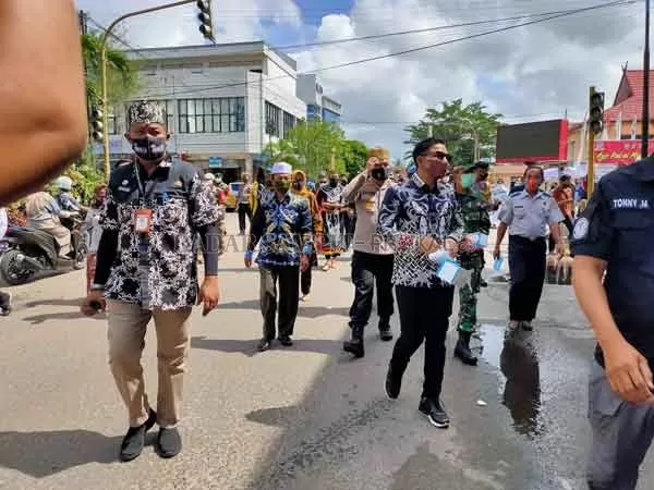 Juru Bicara (Jubir) Satgas Covid-19 Kotim Multazam saat mendampingi Kepala Satgas Covid-19 Kotim Supian Hadi saat melakukan pengawasan penggunaan masker pada warga Kotim. (YUNI/RADAR SAMPIT )