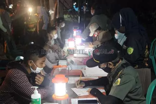 BANYAK TAK PATUH: Petugas Tim Gabungan Satgas Covid-19 Kota Palangka Raya ketika mencatat para pelanggar protokol kesehatan saat  operasi yustisi penegakkan Perwali Nomor 26 Tahun 2020, di pertigaan Jalan Yos Sudarso dan Jalan Raya Galaksi, pada Sabtu (3/10) malam.(istimewa)