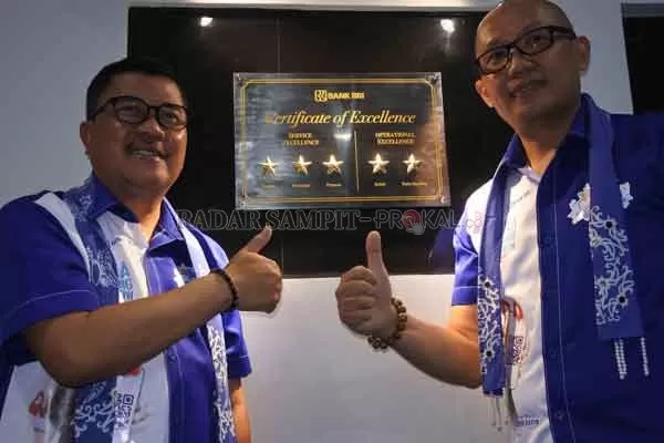 Pemimpin Kantor Wilayah BRI Banjarmasin Hery Santoso dan Pinca BRI Sampit Agung Ari Wibowo menyematkan  lima bintang Certificate of Excellence di BRI Sampit, Senin (5/10) petang.(HERU/RADAR SAMPIT)