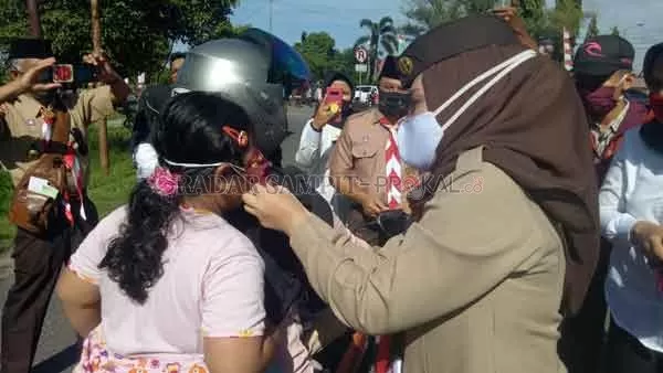 MASKER: Wakil Bupati Seruyan Iswanti memasangkan masker kepada pengendara di Kuala Pembuang belum lama tadi.(IST/RADARSAMPIT)