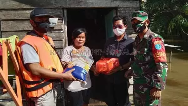 PEDULI : Ketua PWI Kobar Syamsudin (kiri) saat penyerahan bantuan pangan secara simbolis kepada salah seorang warga terdampak banjir di Kelurahan Pangkut didampingi Lurah dan Bhabinsa setempat, Sabtu (24/10) Siang.(SLAMET HARMOKO/RADAR PANGKALAN BUN)