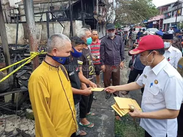 BANTUAN: Bupati Seruyan Yulhaidir (kanan) saat menyerahkan bantuan kepada korban kebakaran di komplek pasar Jalan Ais Nasution Kuala Pembuang belum lama ini. (ALDI SETIAWAN/RADAR SAMPIT)