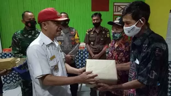 SATGAS : Bupati Seruyan Yulhaidir menyerahkan alat pelindung diri (APD) kepada Kepala Desa Bangun Harja dan perwakilan desa lainnya disela-sela kegiatan pembukaan Satgas Desa Tangkal Covid-19, Kamis (5/11).(HENDRI EDITIA/RADAR SAMPIT)