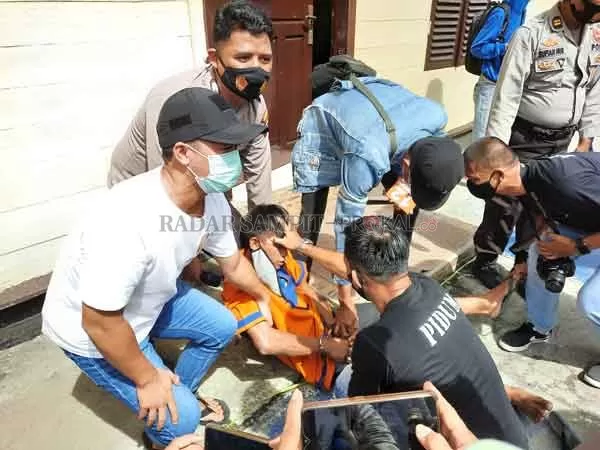 TAK SADAR : Salah satu tersangka pembunuhan ketika berusaha disadarkan petugas kepolisian Polres Batara, karena mengalami kesurupan di tengah rekonstruksi, Jumat (18/12) kemarin.(Alwandi/Radar Sampit)