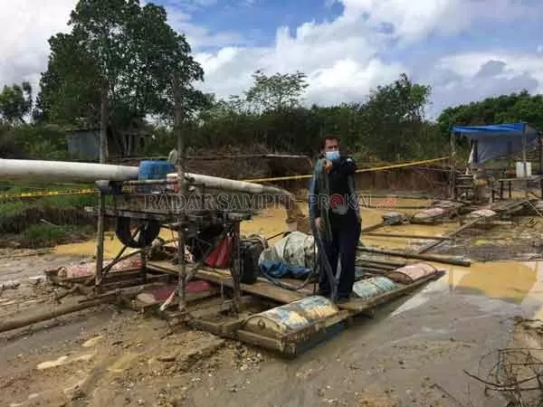 POLICE LINE: Anggota Satreskrim Polres Gumas memasang police line di lokasi ilegal mining, kawasan pertanian Sakata Juri, Kuala Kurun, Rabu (13/1).(FOTO: SATRESKRIM POLRES GUNUNG MAS  )