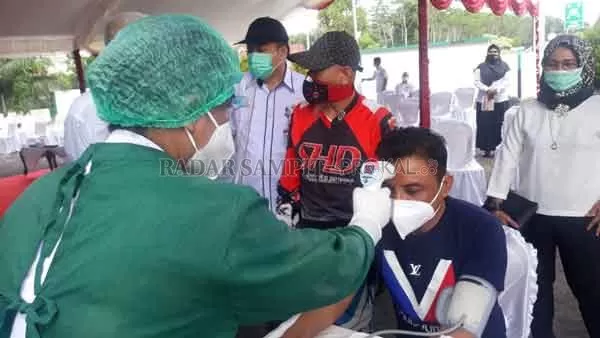 CEK SUHU TUBUH: Pengecekan suhu tubuh dilakukan oleh Nakes, sebelum Bupati Kotim Supian Hadi melakukan screening untuk pencanangan vaksinasi Covid-19.(YUNI/RADAR SAMPIT)
