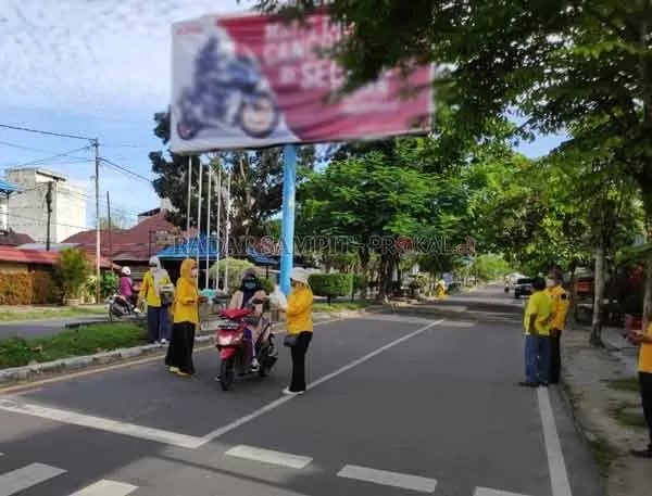 BAGI MASKER : Pengurus DPD Golkar Kobar saat membagikan masker gratis kepada pengguna jalan di Kota Pangkalan Bun. Mereka juga mengimbau agar masyarakat menjaga kondusifitas daerah pasca pelaksanaan Pilkada Kalteng.(ISTIMEWA/RADAR PANGKALAN BUN)
