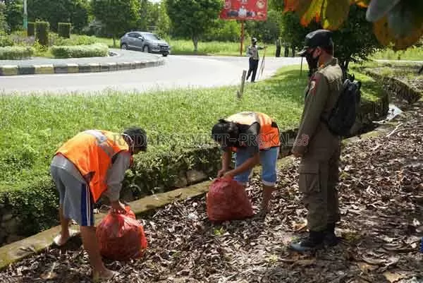 OPERASI YUSTISI : Masyarakat yang tak taat protokol kesehatan disanksi kerja sosial saat petugas menggelar razia masker di Bundaran Garuda – Jalan Bukit Keminting, Palangka Raya, Kamis (11/2) kemarin.(IST/RADAR PALANGKA)