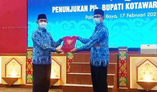 SERAHKAN SK: Sekda Kalteng Fahrizal Fitri mewakili Gubernur Sugianto Sabran menyerahkan SK tentang Penunjukan Plh. Bupati Kotawaringin Timur kepada Akhmad Husain, Rabu (17/2).(YUSHO/RADAR SAMPIT)