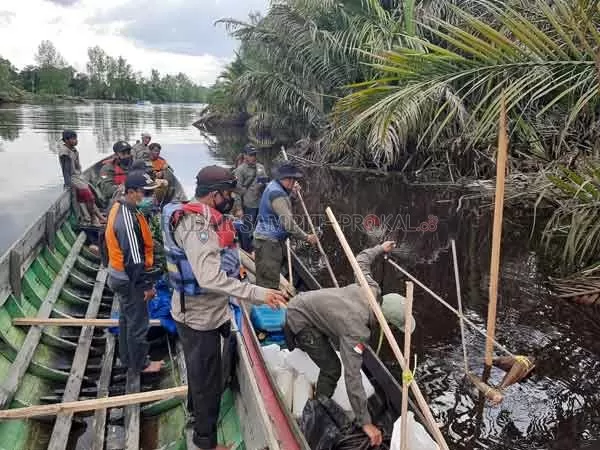 CARI BUAYA: Anggota Polsek Sabangau bersama petugas BKSDA Provinsi Kalteng memasang perangkat buaya di sungai Sabagau, kemarin.(  POLSEK SABANGAU For RADAR SAMPIT)