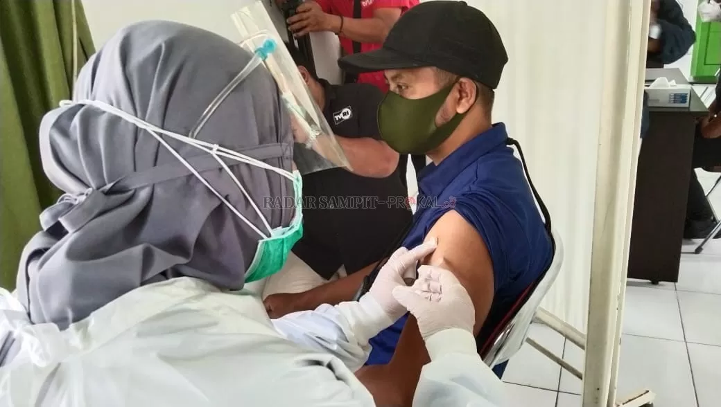 VAKSINASI COVID-19 : Ketua PWI Kotawaringin Barat Syamsudin yang merupakan Kepala Biro Radar Sampit, Pangkalan Bun saat mendapat suntikan vaksin Covid-19, di Puskesmas Pelingkau, Kelurahan Baru, Kecamatan Arut Selatan, Senin (8/3). (SLAMET HARMOKO/RADAR PANGKALAN BUN)