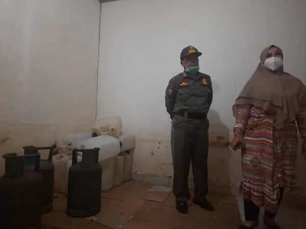 ADA TIKUS: Wakil Bupati Kotim Irawati membuka salah satu panci yang digunakan untuk proses pembuatan miras, Senin (3/5). Dalam panci itu, Irawati mendapati bangkai tikus dalam air yang diduga hasil fermentasi untuk arak.(GUNAWAN/RADAR SAMPIT)