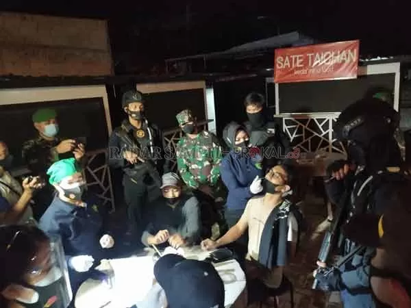OPERASI YUSTISI: Operasi Yustisi berskala besar melibatkan unsur TNI dan Kepolisian dilaksanakan, salah seorang pengunjung kafe sedang menjalani pengambilan sampel untuk rapid antigen, Sabtu (22/5).(SULISTYO/RADAR PANGKALAN BUN)