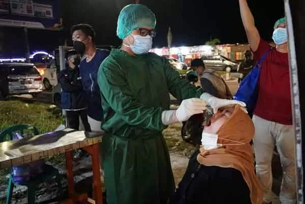 MERINGIS: Salah satu pengunjung cafe saat dilakukan pemeriksaan test swab antigen oleh tim satgas Covid-19, di sela sedang menikmati kuliner di salah satu cafe, Sabtu (5/6) malam.(istimewa)