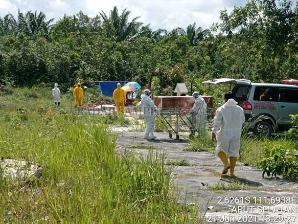 PEMAKAMAN: Petugas pemakaman saat menurunkan jenazah pasiesn Covid-19 untuk dimakamkan. Saat ini jumlah warga terkonfirmasi positif Covid-19 Kobar terus meningkat, sedangkan di sisi lain ruang isolasi di rumah sakit kian terbatas. (FOTO: ISTIMEWA/RADAR SAMPIT)