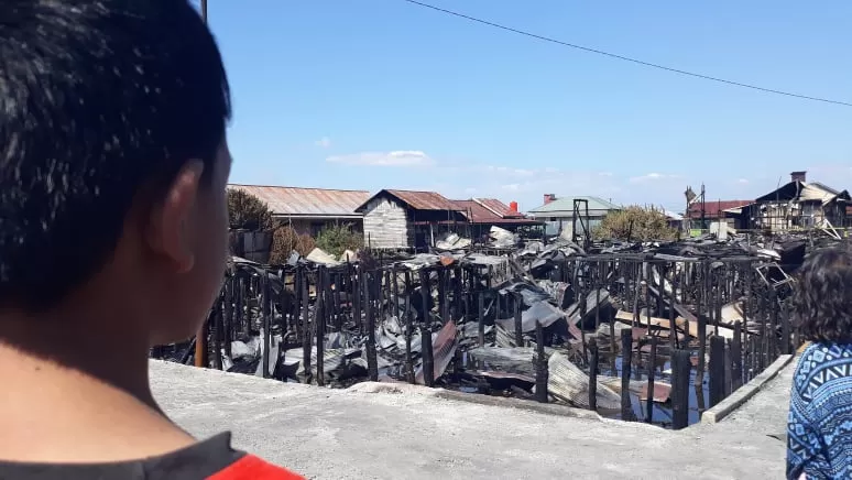 Seorang anak menatap puing sisa kebakaran di Palangka Raya.