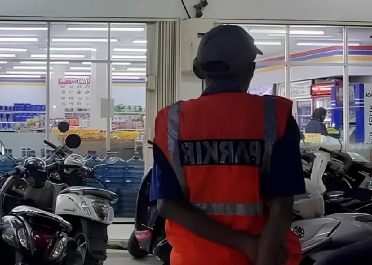 Petugas parkir di area minimarket tengah berjaga pada jam operasional, ilustrasi aktivitas parkir di fasilitas publik.  (Instagram/bushcoo)