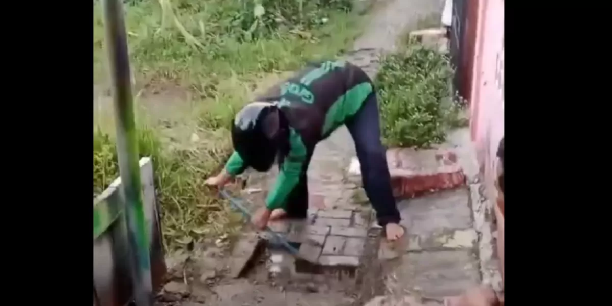 Seorang driver Grab terekam membongkar konblok jalan lingkungan.  (X/neVerAl0nely___)
