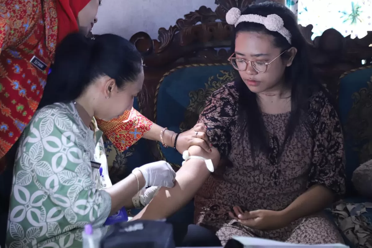  Febriyanti Rizkyanggini, warga Dusun Tenap, Desa Sucopangepok, Kecamatan Jelbuk, saat mendapatkan pemeriksaan di rumahnya (Dok Diskominfo Jember)