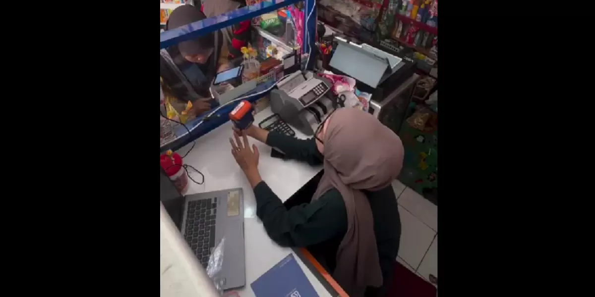 Penjaga toko menunjukkan detail transaksi BRIVA di layar ponsel. (X/RadioElshinta)