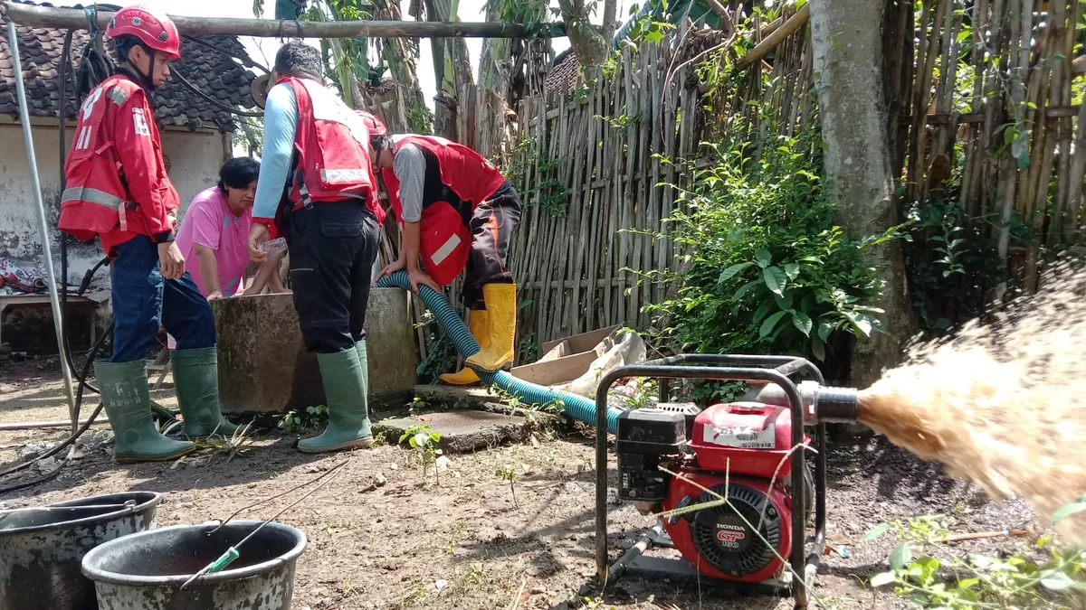 Tim Relawan WASH PMI Jember saat menormalisasi sumur warga yang tercemar lumpur akibat banjir (PMI Jember)