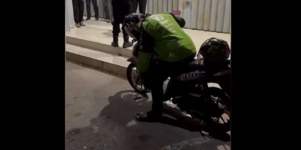 Petugas dan warga saat mengevakuasi pengemudi ojek online yang ditemukan meninggal di atas sepeda motornya di kawasan Palm Spring, Batam Kota.  (X/dhemit_is_back)