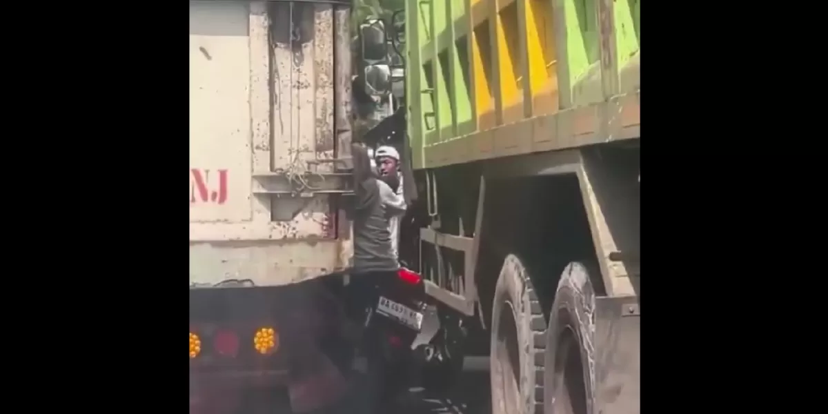 Tangkapan layar video yang memperlihatkan seorang ibu pengendara motor terjepit di antara dua truk besar saat kondisi lalu lintas padat. (X/neVerAl0nely___)
