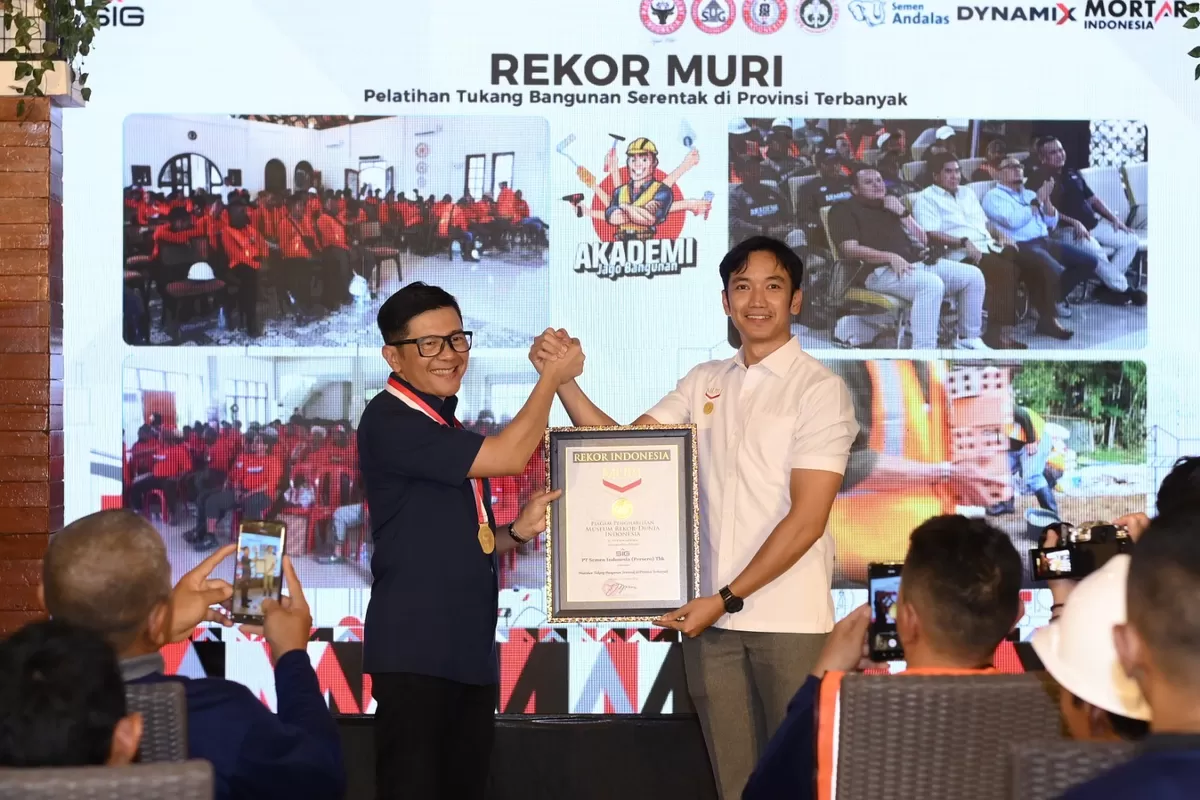 Direktur Sales dan Marketing SIG, Dicky Saelan (kiri) menerima Piagam Penghargaan Museum Rekor&ndash;Dunia Indonesia (MURI) atas Rekor Pelatihan Tukang Bangunan Serentak di Provinsi Terbanyak