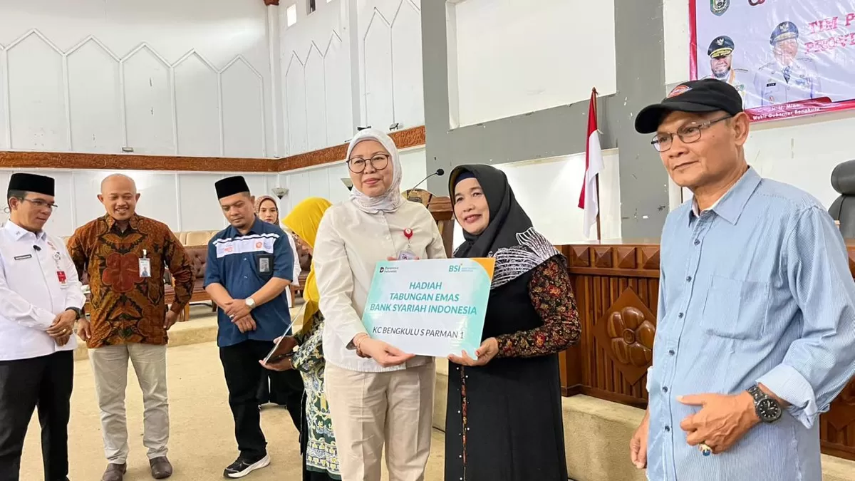 Kepala OJK Bengkulu, Ayu Laksmi  Syntia Dewi menyerahkan tabungan umroh Bank Syariah kepada  peserta edukasi dan inklusi keuangan syariah yang dilaksanakan OJK dan TPAKD Pemprov Bengkulu.(Foto/Ist)