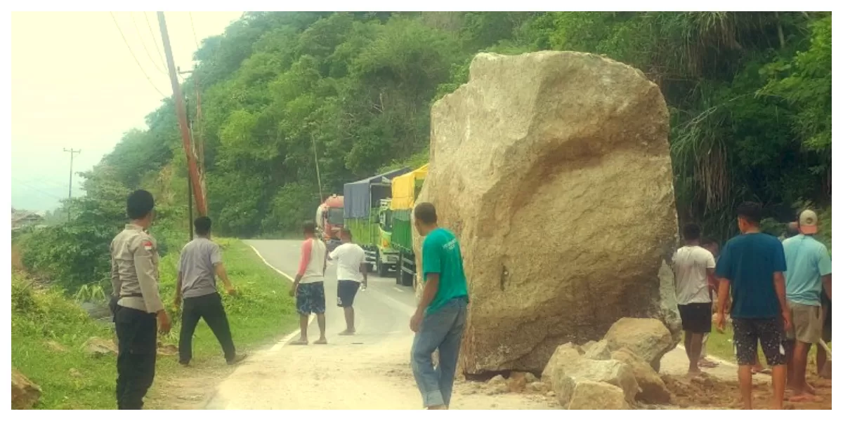 Petugas kepolisian dan warga membersihkan material longsor di Jalur Trans Flores Km 34 Nangapanda Ende, Minggu pagi, akibat cuaca ekstrem. 