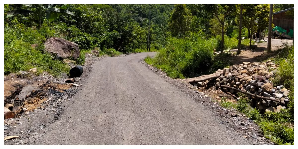 Kondisi ruas Jalan Lapen Warat Paan Leleng&ndash;Balus Permai di Desa Ngampang Mas yang permukaannya masih kasar dan dipenuhi material batu lepas. (Foto/ Acong Harson)